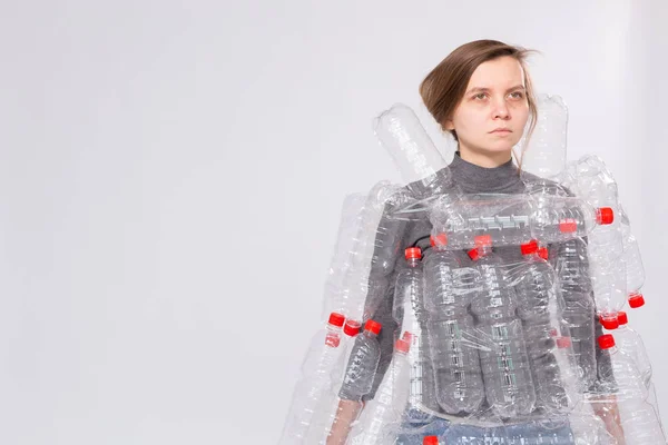 Mujer enferma deshidratada está de pie con vestido en botellas de plástico. Problema de contaminación ambiental. Detener la naturaleza basura concepto de protección del medio ambiente sobre fondo blanco con espacio de copia — Foto de Stock