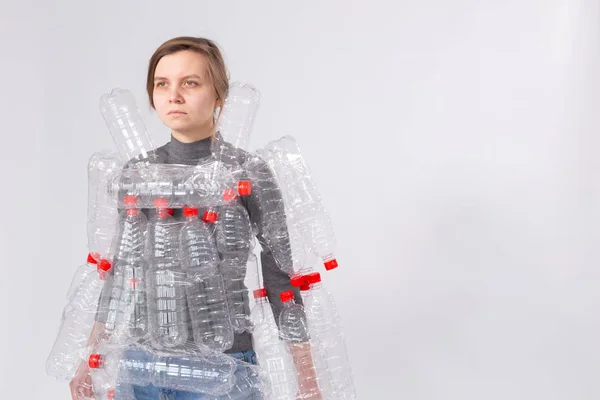 Protección del medio ambiente, personas y concepto de plástico reciclable - mujer agotada preocupada por el desastre ambiental con vestido como botellas de plástico sobre fondo blanco con espacio de copia — Foto de Stock