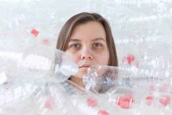 Protección del medio ambiente, personas y concepto de plástico reciclable: mujer exhausta preocupada por el desastre ambiental sentada en una pila de botellas de plástico — Foto de Stock