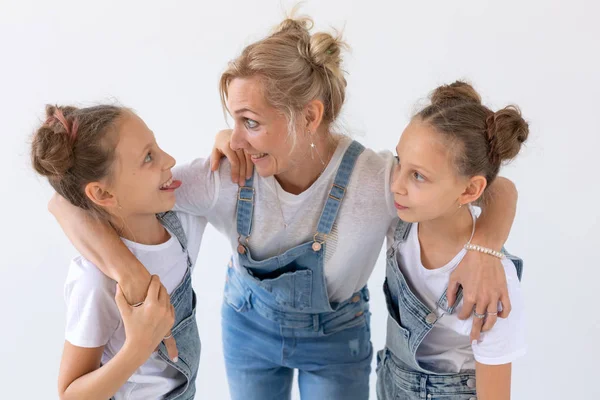 Familia, hermanas y concepto de amor - Madre abrazando a dos hijas gemelas sobre fondo blanco — Foto de Stock