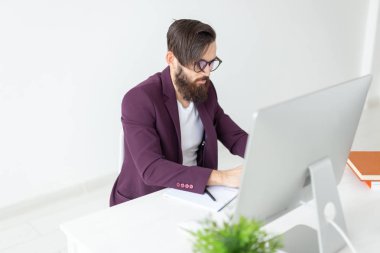 İnsan ve teknoloji kavramı - adam oturur ve bilgisayarda çalışır