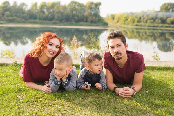 Los niños, la paternidad y el concepto de la naturaleza - Gran familia acostada en la hierba — Foto de Stock