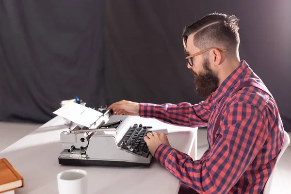 Gente, escritor y concepto hipster - joven escritor elegante que trabaja en la máquina de escribir — Foto de Stock