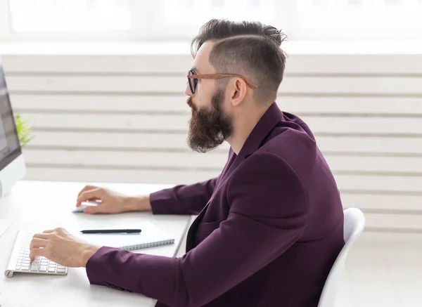 Concepto de personas y tecnología - Retrato de vista lateral del hombre guapo vestido con chaqueta púrpura trabajando en el ordenador — Foto de Stock