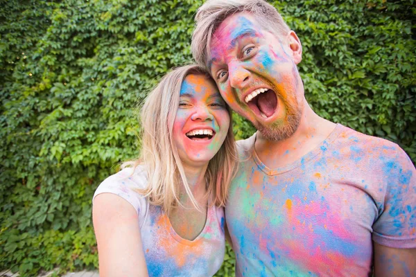 Festival holi, conceito de pessoas - jovem casal tomando selfie em roupas sujas coloridas — Fotografia de Stock