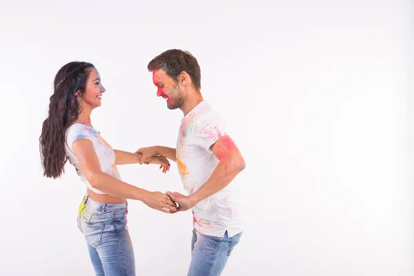 Festival de holi, danza social, amistad - jóvenes jugando con colores en el festival de holi y bachata bailando o kizomba sobre fondo blanco con espacio de copia — Foto de Stock