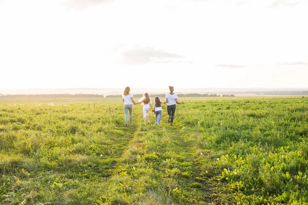 Familien-, Sommer- und Urlaubskonzept - Gruppe von Frauen und Mädchen auf der grünen Wiese — Stockfoto