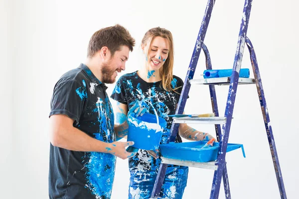 Riparazione, ristrutturazione e concetto di persone - coppia andando a dipingere il muro, stanno preparando il colore e spazzole — Foto Stock