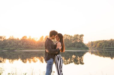 Aşk, romantik ve doğa kavramı - göl kenarında sarılma genç çift