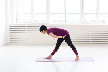 Yoga, meditasyon, insanlar kavramı - orta yaşlı bir kadın spor salonunda bir yoga yaparken