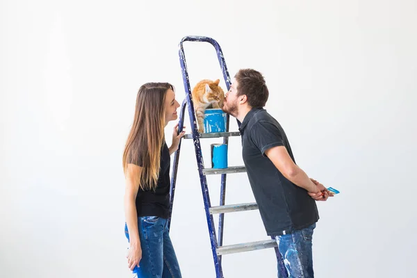 Personnes, redécoration et concept de relation - Jeune couple drôle avec chat faisant de la rénovation dans un nouvel appartement — Photo