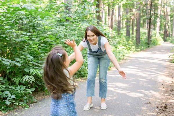 Природа, развлечения и семейная концепция - мать и ребенок гуляют в лесу и играют — стоковое фото