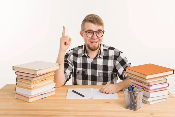 Concepto de personas, conocimiento y educación - Estudiante inteligente sentado a la mesa con libros y cuaderno — Foto de Stock