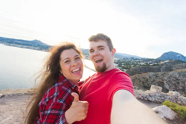 Koncepcja podróży, wakacji i wczasów - para piękny posiadające zabawy, biorąc selfie, szalony twarze emocjonalne i śmiejąc się. — Zdjęcie stockowe