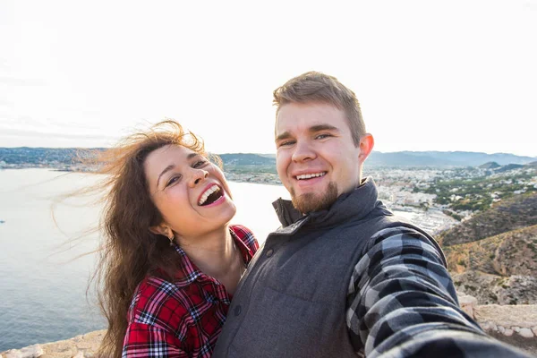 Podróże, turystyka i urlop koncepcja - szczęśliwe małżeństwo biorąc selfie w pobliżu morza — Zdjęcie stockowe