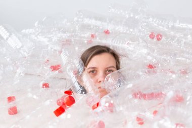 Çevre Koruma, insanlar ve geri dönüştürülebilir plastik kavram - bir yığın plastik şişe oturan çevre felaketi ile ilgili yorgun kadın