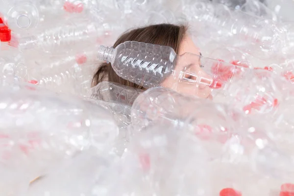 Protección del medio ambiente, personas y concepto de plástico reciclable: mujer exhausta preocupada por el desastre ambiental sentada en una pila de botellas de plástico — Foto de Stock