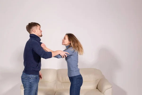 Concepto de personas, violencia y abuso - joven agresivo golpeando a su novia en su brazo —  Fotos de Stock