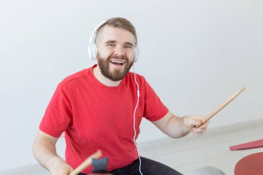 İnsanlar, müzik ve hobi konsepti - Boş zamanlarını davul çalarak geçiren mutlu adam