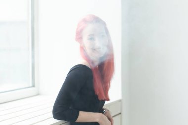 Vape, bağımlılık ve insan kavramı - kızıl saçlı kadın vape sigara