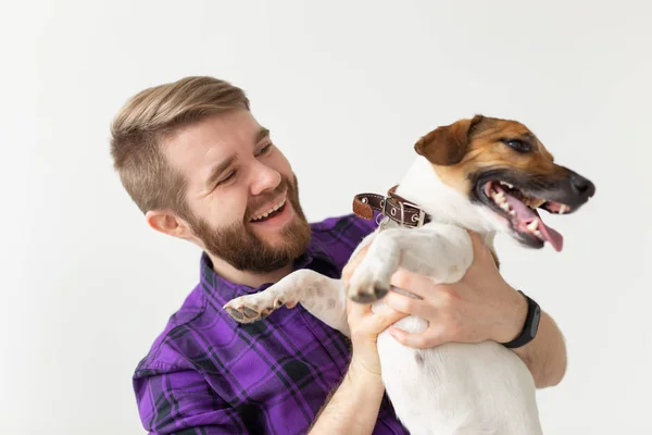 Animal, mascota y gente concepto - sonriente hombre feliz sosteniendo su pequeño gato russell terrier perro sobre fondo blanco — Foto de Stock
