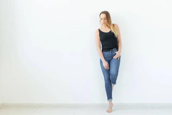 Estilo, conceito de pessoas - jovem mulher de jeans e camisa preta em pé sobre o fundo branco com espaço de cópia — Fotografia de Stock