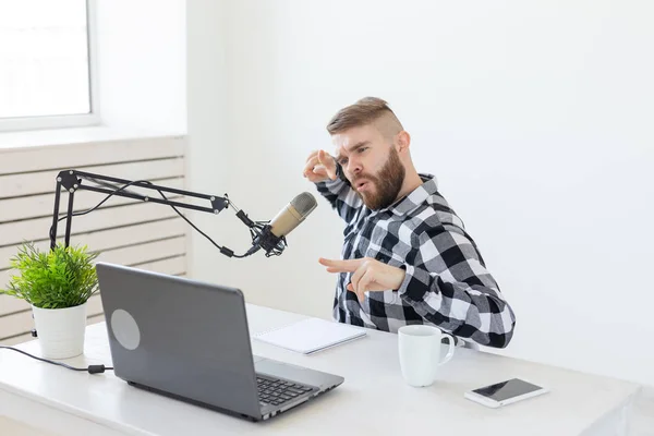 Anfitrión de radio, streamer y blogger concepto - Hombre guapo trabajando como locutor de radio en la estación de radio sentado frente al micrófono — Foto de Stock