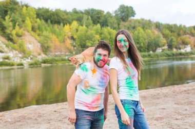 Festival holi, turizm ve doğa kavramı - kadın ve erkek kedi ile portre çok renkli toz kaplı.