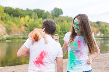Festival holi, tatil, turizm, evde beslenen hayvan ve doğa kavramı - kadın ve erkek kedi ile portre çok renkli toz kaplı.
