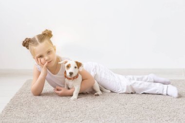 Çocukluk, Evcil hayvan ve köpekler kavramı - küçük çocuk kız köpek yavrusu ile katta poz