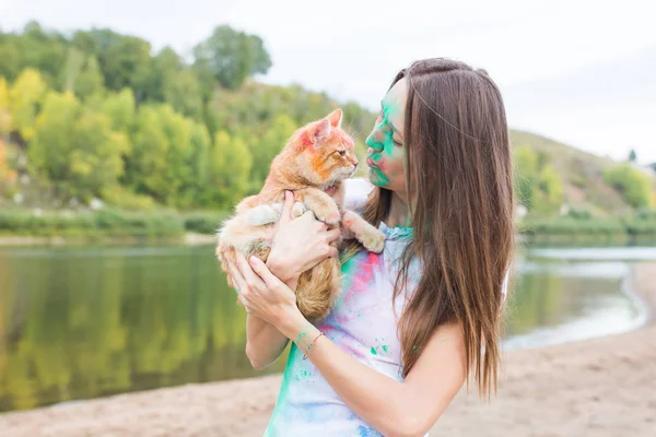 축제 holi, 휴일, 관광, 애완 동물 및 자연 개념-고양이 함께 여자의 초상화 덮여 멀티 컬러 먼지 — 스톡 사진