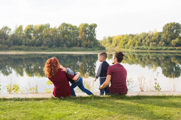 Kindheits- und Naturkonzept - Familie mit kleinen Söhnen im grünen Gras — Stockfoto