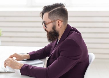 İnsan ve teknoloji kavramı - yan görünümü bilgisayar üzerinde mor ceket giymiş yakışıklı adam portresi