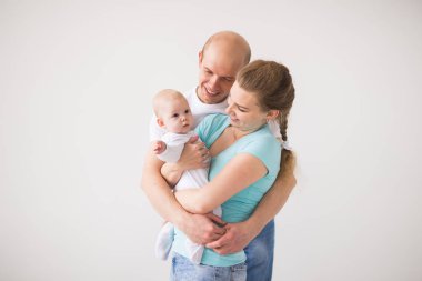 Gururlu anne ve baba yeni doğan bebek kızları kopya alanı ile beyaz arka plan üzerinde gülümseyen