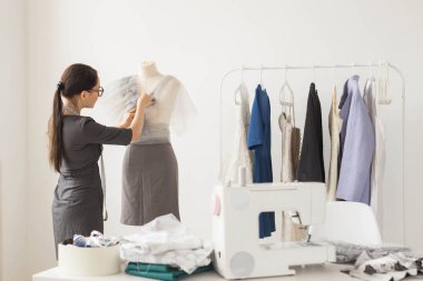 İnsanlar ve moda kavramı - Back view manken ofis malzemeleri ölçme şık kıyafeti giymiş moda dükkanı sahibi