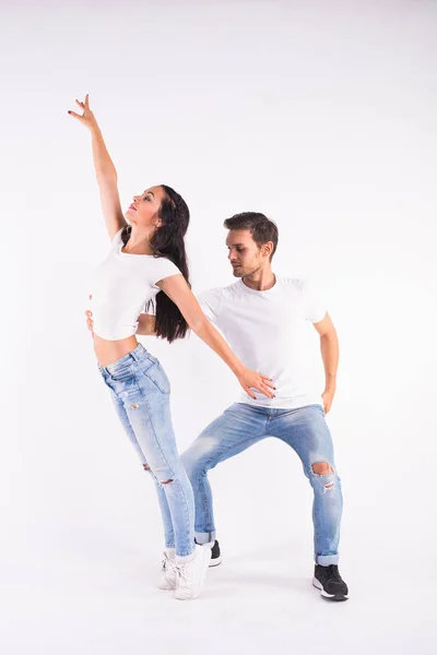 Giovane coppia che balla bachata di danza sociale, merengue, salsa, kizomba. Due posa eleganza sulla stanza bianca . — Foto Stock