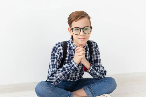 Teenager, Kinder und Modekonzept - niedliches Kind mit Brille auf dem Boden vor weißem Hintergrund — Stockfoto