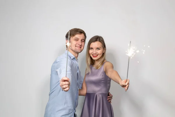 Oslava, zábava a dovolená concept - šťastný muž a žena drží hůl ohňostroj nebo prskavky — Stock fotografie