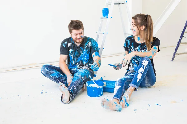 Reparação, renovação e conceito de pessoas - casal vai pintar a parede e se divertir no intervalo — Fotografia de Stock