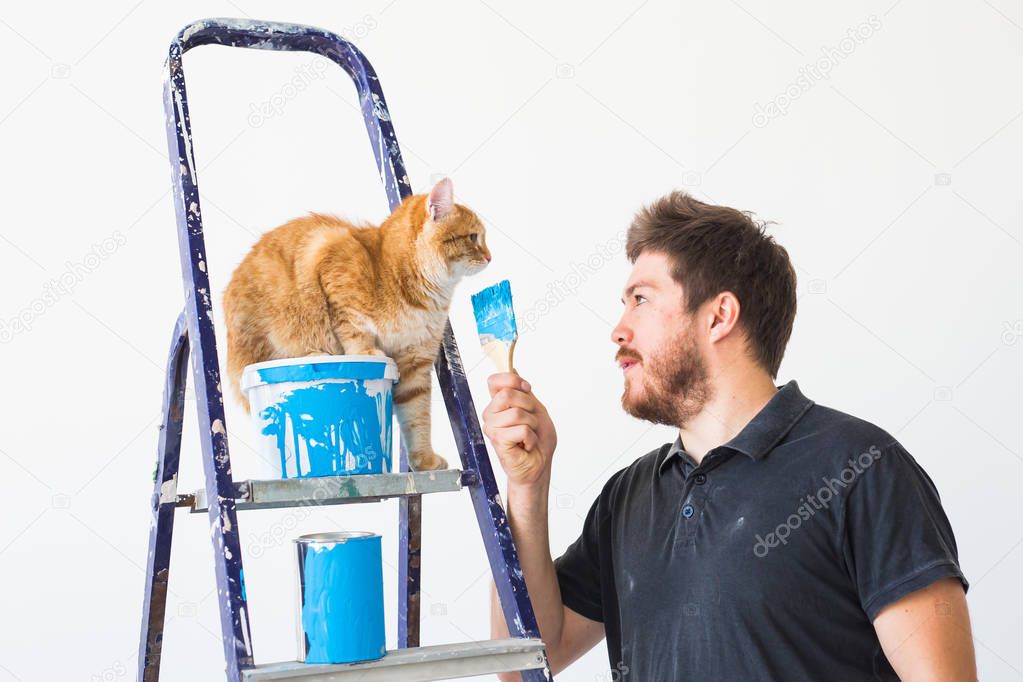 Renovation, redecoration and family concept - Young man stroking a cat during renovation in apartment