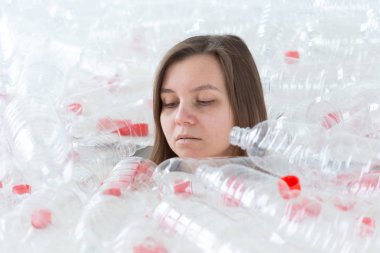 Plastik kirlilik sorunu ve çevre koruma. Plastik şişe yığını içinde zayıf yorgun kadın. Earth konsepti kaydedin. Doğanın temizliği.