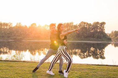 Romantik, sosyal dans ve insanlar kavramı - genç çift bachata günbatımı arka dans