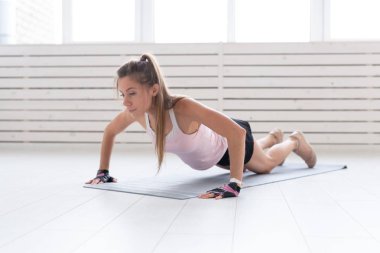 Sağlıklı yaşam, spor, insanlar kavramı - genç bir kadın fitness spor salonu ya da ev yapıyor. O spor elbiseli baskı yapıyor