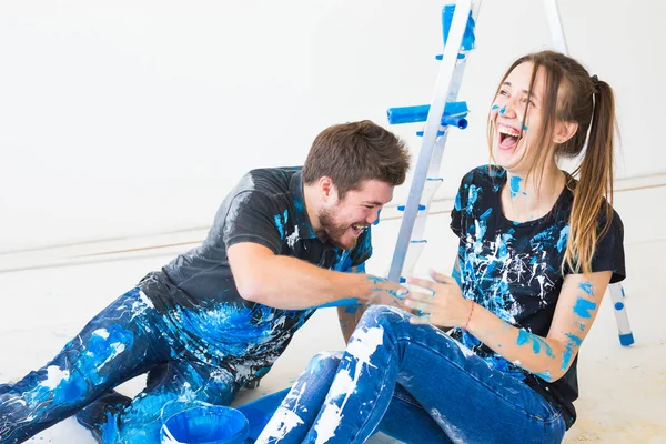 Pessoas, redecoração e conceito de relacionamento - Jovem casal engraçado fazendo renovação em novo apartamento e se divertir no intervalo — Fotografia de Stock