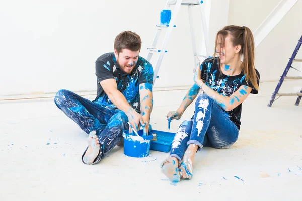 Reparación, renovación y concepto de personas - pareja va a pintar la pared y divertirse en el descanso — Foto de Stock