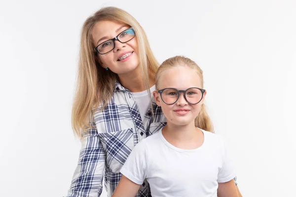 Jovem mãe feliz e criança rindo em óculos de moda se divertir no fundo branco — Fotografia de Stock