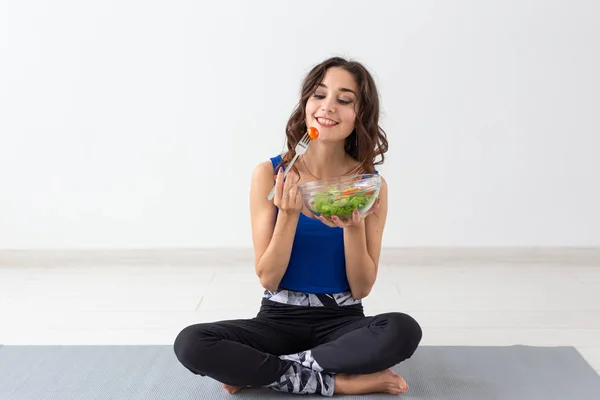 Υγιεινού τρόπου ζωής, άνθρωποι και sport concept - γιόγκα γυναίκα με ένα μπολ σαλάτα λαχανικών — Φωτογραφία Αρχείου