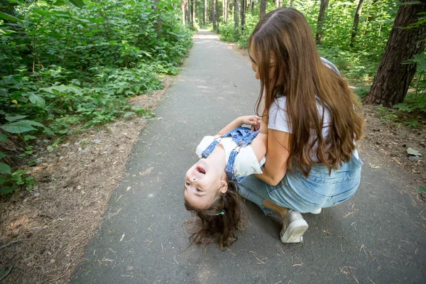 Familia y concepto de la naturaleza - Mujer joven con niña se divierten al aire libre —  Fotos de Stock