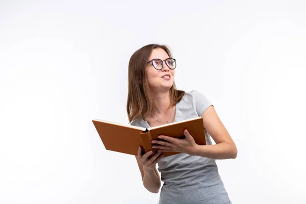 Menschen und Bildungskonzept - attraktive Frau liest ein Buch vor weißem Hintergrund — Stockfoto