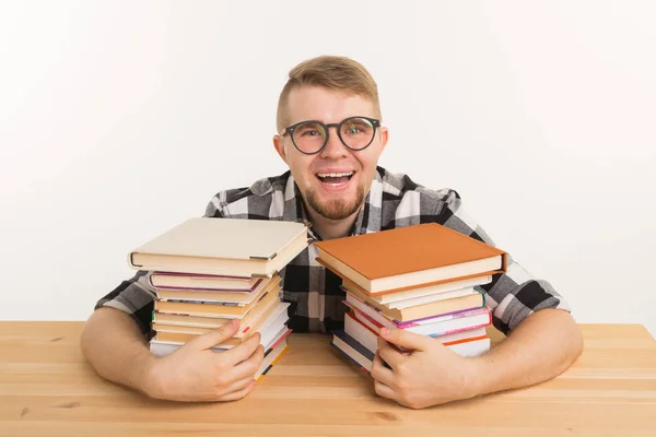 Persone, conoscenza e concetto di istruzione - Guy seduto abbracciando un libro al tavolo di legno — Foto Stock